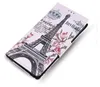 A close-up, angled view of a white flip-style phone case with a decorative print of the Eiffel Tower and flowers. Produktbild-Vorschau