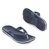 A pair of navy blue Crocs flip-flops are shown against a white background. One flip-flop is shown from the top, and the other is shown from the bottom, angled to display the sole. Produktbild-Vorschau