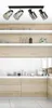 A modern kitchen interior with shelves and cabinets, featuring a ceiling light fixture. Produktbild-Vorschau