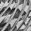 A close-up, black and white image of razor wire. Produktbild-Vorschau