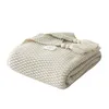 A folded knitted blanket with tassels and decorative beads. Produktbild-Vorschau