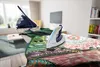 An iron and a steam generator station are on an ironing board with clothes. Anteprima dell’immagine prodotto