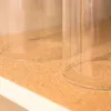 Close-up of two clear glass cylinders on a cork-like surface. Produktbild-Vorschau