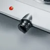 A close-up of a black and silver electric stove knob and a red indicator light on a brushed metal surface. Náhled obrázku produktu