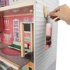 A hand is shown turning a wooden knob on the side of a dollhouse. Náhľad obrázku produktu