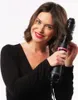 A woman is using a Revlon hair dryer and volumizer on her hair against a white background. Voir les images du produit
