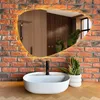 A modern bathroom vanity with a white basin sink and a black faucet, set against a brick wall and a wooden countertop. A snake plant in a white pot adds a touch of greenery. Náhled obrázku produktu