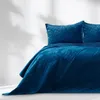 A close-up shot of a quilted bedspread and pillows on a bed. Produktbild-Vorschau