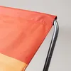 Close-up of the fabric edge of a folding chair, showing the stitching and metal frame. Náhled obrázku produktu