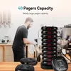 A man is working behind a counter in what appears to be a cafe or restaurant, with a stack of pagers on the counter. Produktbild-Vorschau