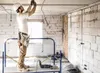 An electrician working on wiring in a room under construction. Produktbild-Vorschau