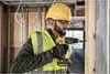 A construction worker is using a DeWALT cordless drill to screw into a wooden beam on a construction site. Anteprima dell’immagine prodotto
