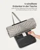 A hand is shown opening a zipper on a rolled-up picnic blanket to reveal stakes. Produktbild-Vorschau