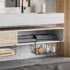 A bathroom vanity area with a sink, faucet, and storage shelves. The product, a set of hanging storage baskets, is shown attached to the underside of a shelf, holding various bathroom items. Produktbild-Vorschau