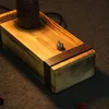Close-up of the base of a vintage-style table lamp made of wood with metal accents and a toggle switch. Produktbild-Vorschau