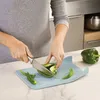 A person is chopping a green bell pepper on a light blue cutting board in a kitchen. Náhľad obrázku produktu