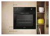 A built-in oven is shown in a kitchen setting, integrated into cabinetry. Shelving with kitchenware is visible to the right. Náhľad obrázku produktu