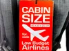 A close-up of a red tag attached to a gray backpack, advertising cabin size for low-budget airlines. Produktbild-Vorschau