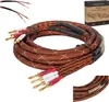 A coiled brown audio-video cable with banana plugs and a product box in the background. Podgląd zdjęcia produktu