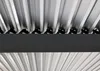 A close-up view of the underside of a pergola's roof structure, showing the metal lamellas and supporting beams. Produktbild-Vorschau