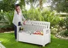 A woman is opening a white storage bench in a garden. Náhľad obrázku produktu