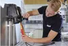 A technician is using a voltage tester on an electrical device in a laboratory or workshop setting. Náhľad obrázku produktu