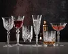 A collection of crystal glassware filled with different beverages, arranged on a dark surface with a textured background. Náhled obrázku produktu