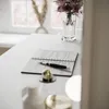A desk with a notebook, pen, and decorative items. Produktbild-Vorschau