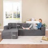 A woman is relaxing on a large, dark gray sectional sofa in a living room setting. Produktbild-Vorschau