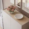 A modern sideboard with a wooden top, decorated with a vase of flowers and a bowl. Produktbild-Vorschau