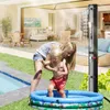 A woman is helping a child play in a small inflatable pool next to a larger pool, with a solar shower in the background. Produktbild-Vorschau