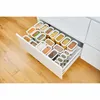 An open kitchen drawer filled with various transparent food storage containers of different sizes and shapes, neatly organized and containing different dry food items like pasta, grains, and spices. Voir les images du produit