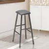 A gray metal bar stool with a faux leather seat is shown in a kitchen setting. Voir les images du produit