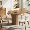 A dining set with a round wooden table and four chairs in a well-lit room. Produktbild-Vorschau