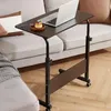 A dark brown rolling laptop table with a laptop, a small pastry, and a spoon on it, placed next to a light gray sofa with tan cushions. Anteprima dell’immagine prodotto