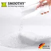 White background with a pile of white EPS beads being poured from a clear glass. Anteprima dell’immagine prodotto