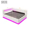 A white upholstered bed frame with pink LED lighting underneath and around the headboard, showing dimensions. Náhled obrázku produktu