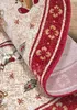 A close-up view of a rolled-up rug with a festive Christmas design. Podgląd zdjęcia produktu