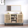 A wooden sideboard with slatted doors and black metal legs, displayed in a room setting with decorative items and a framed picture on the wall. Produktbild-Vorschau