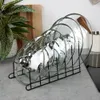 A black metal rack holding several clear glass pot lids with silver handles is displayed on a countertop. Produktbild-Vorschau