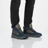 A person wearing dark jeans and blue and beige Timberland Field Trekker Mid Boots. Produktbild-Vorschau