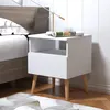 A white nightstand with a drawer and an open shelf sits next to a bed. Náhľad obrázku produktu