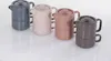 Four teapots of different colors are arranged in a row on a white surface. Podgląd zdjęcia produktu