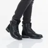 A person wearing black jeans and black boots. Anteprima dell’immagine prodotto