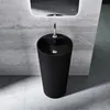 A modern black freestanding pedestal sink in a bathroom with a concrete wall and floor. Produktbild-Vorschau