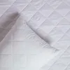 A close-up view of a white quilted mattress protector, with one corner folded over. Anteprima dell’immagine prodotto