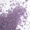 A pile of purple sprinkles scattered on a white surface. Voir les images du produit