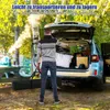 A man is loading items into the trunk of a car, with a pop-up tent bag on the ground next to him. Náhľad obrázku produktu