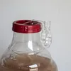 Close-up of a fermentation airlock attached to a clear plastic container lid. Produktbild-Vorschau