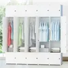 A modular wardrobe with clothes hanging inside, set against a bright window with greenery visible outside. Náhľad obrázku produktu